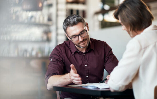 Cropped shot of two businesspeople working together in a local cafe